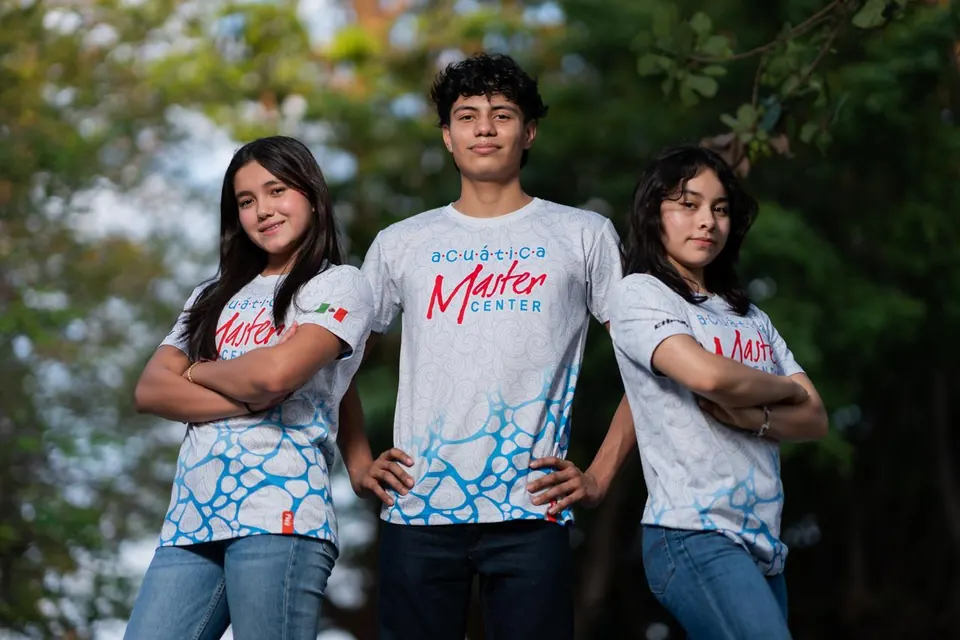 Tres nadadores del club posan con la playera de Acuática Master Center